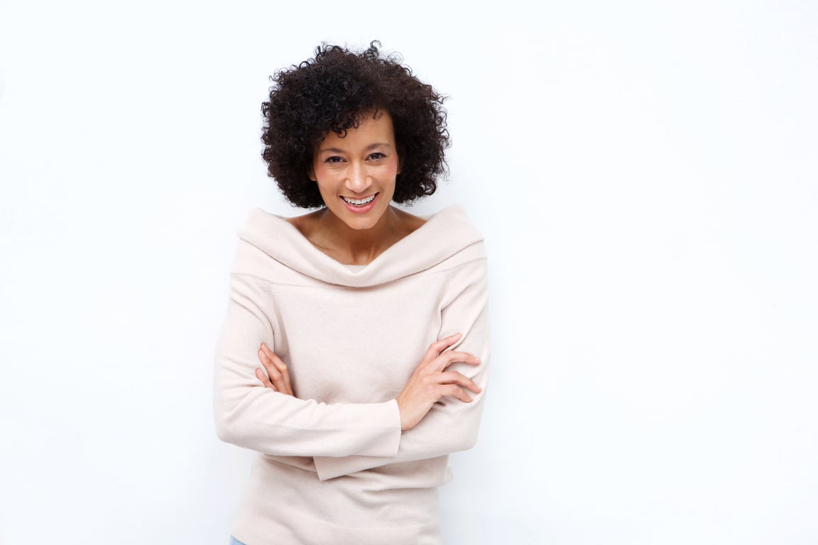 Older Woman Smiling with Arms Crossed against White Background